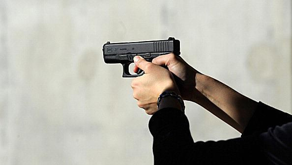 Hender som holder en pistol
