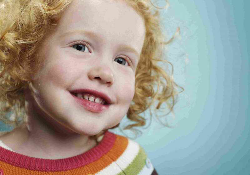 Portrett av en smilende 3 år gammel jente.