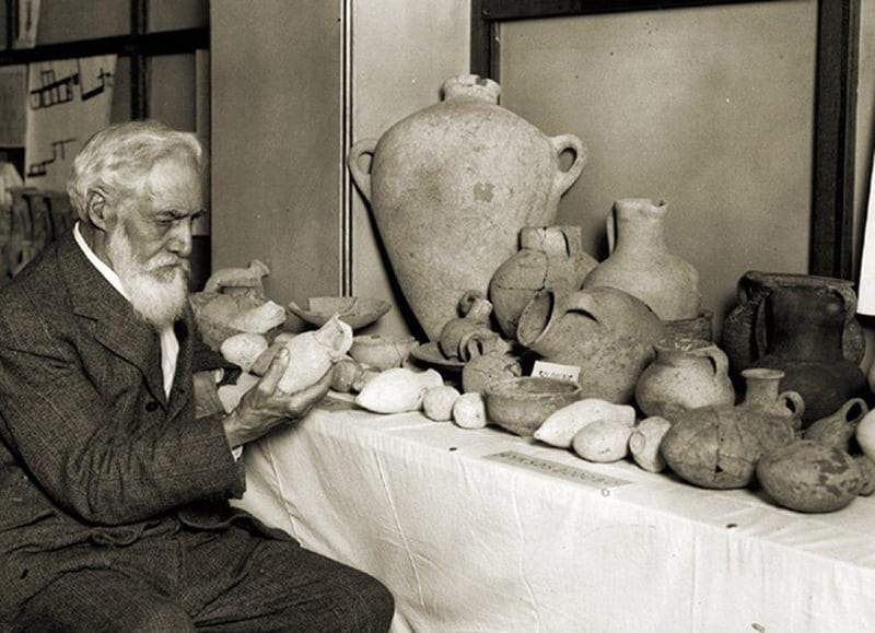 Flinders Petrie examinând unele dintre descoperirile sale, 1930.