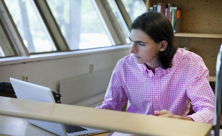 Młody mężczyzna studiujący w bibliotece