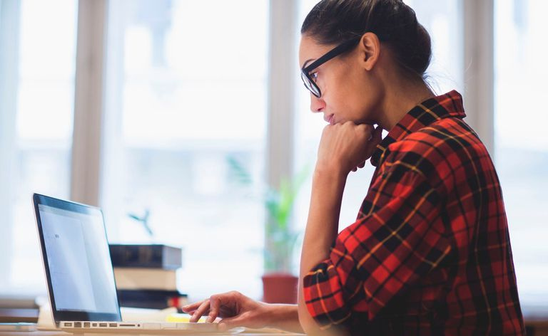 Eine Frau, die an einem Computer arbeitet und Software zur Analyse qualitativer Daten verwendet.