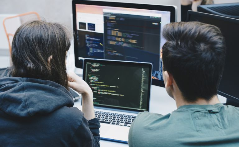 vista trasera de dos programadores en una computadora