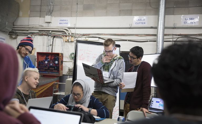 I team di hacker effettuano il brainstorming di un hackathon di lavoro sui laptop in officina