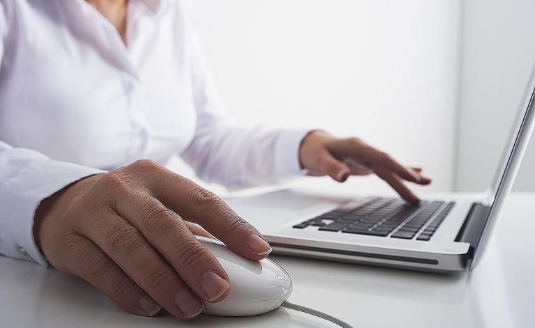 kobieta korzystająca z laptopa i myszy