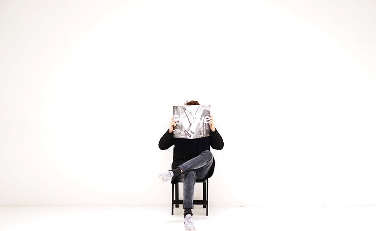 Homme assis sur une chaise et lisant un magazine