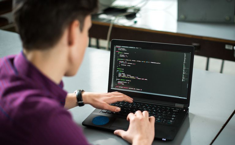 Jovem usando seu laptop para tentar resolver o problema com o código