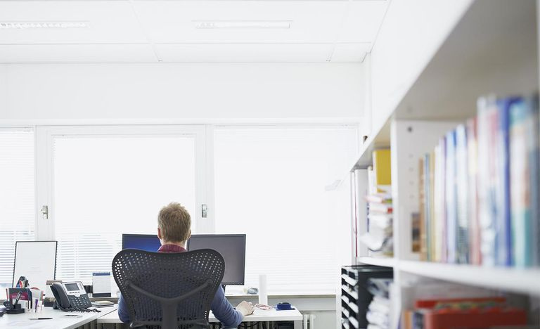 Homem de negócios sentado na frente do computador, backview