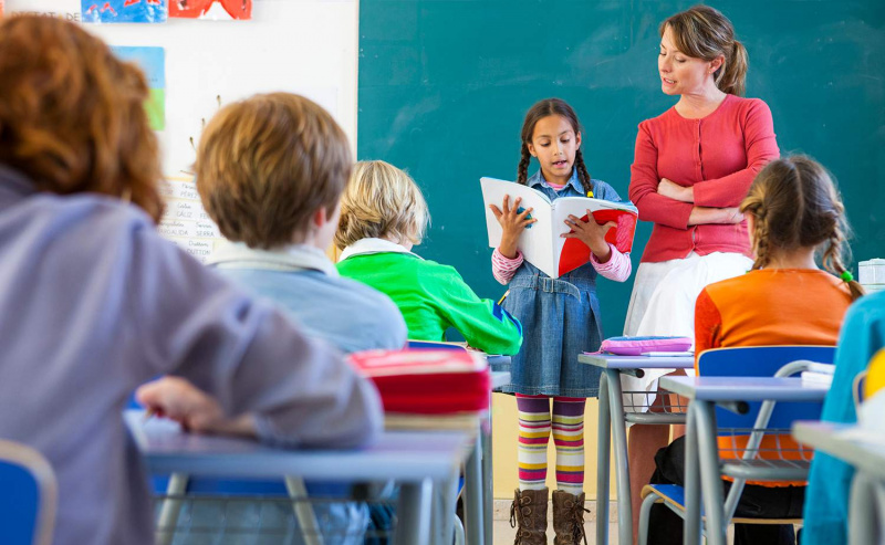 Grundschülerin liest vor dem Klassenzimmer