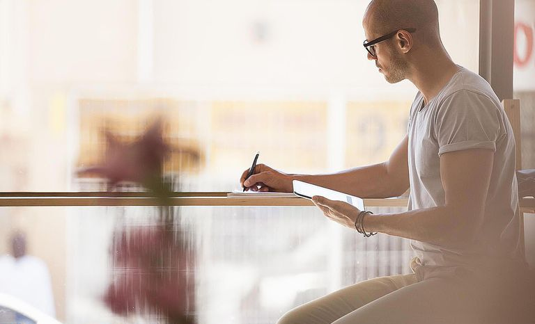 Homme utilisant une tablette numérique au café
