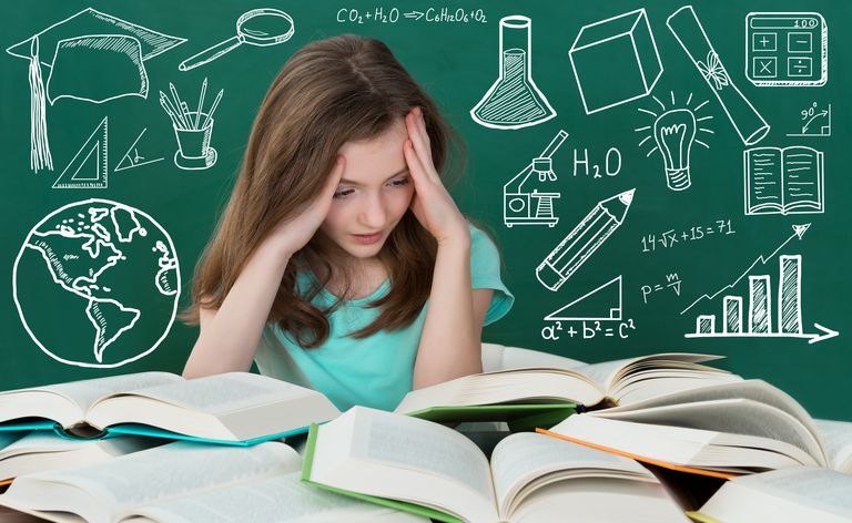 Chica frustrada mirando muchos libros en el escritorio