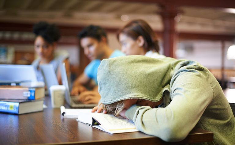Młody student w grupie studyjnej cierpiący na wyczerpanie matur.