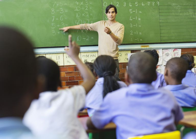 Profesor apuntando al problema de matemáticas en la pizarra