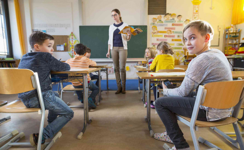 deti pri stoloch pozerajú späť