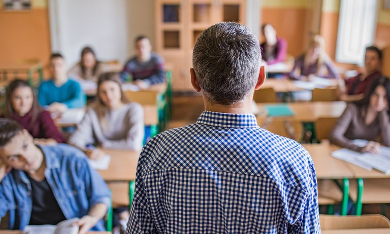 Rückansicht eines Highschool-Lehrers, der einen Vortrag hält.