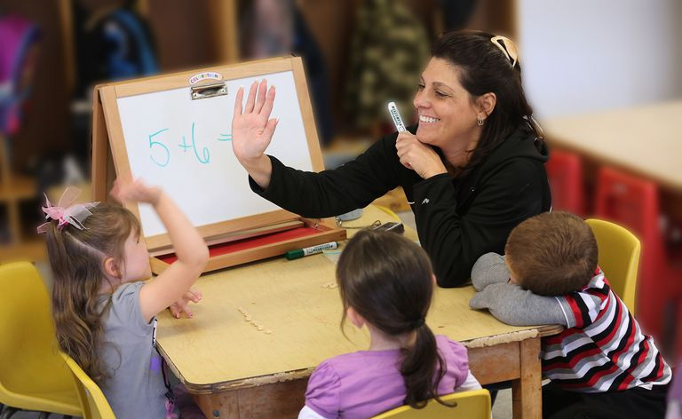 Skolotājs apsveic matemātikas studentu