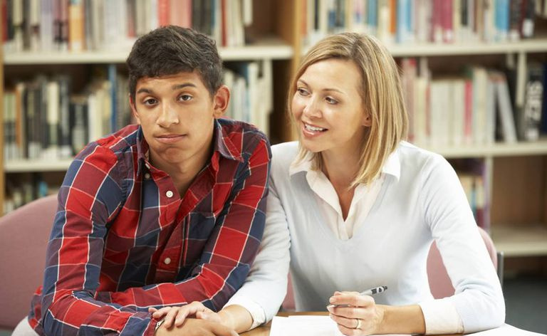 Un étudiant avec un professeur dans la bibliothèque
