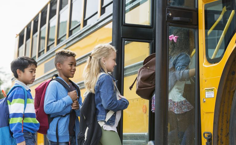 Kinder steigen in einen Schulbus