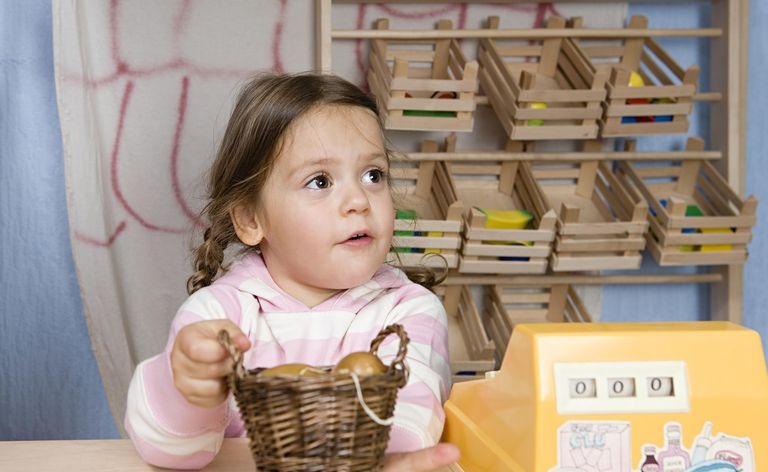 Un bambino piccolo che finge di essere il cassiere durante una partita a