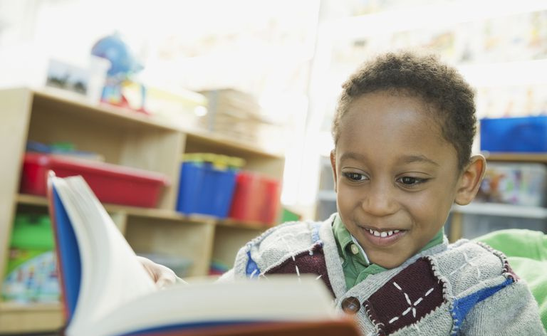 Libro di lettura sorridente del ragazzo