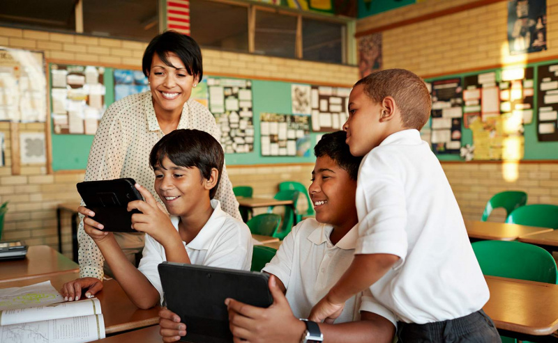 Profesor y alumnos mirando tablet