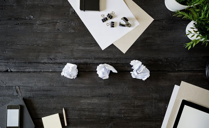 Feuilles de papier vierges, crayon, smartphone et papiers émiettés sur bois noir