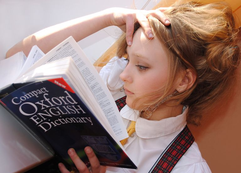 英語の辞書を見ている若い女の子。