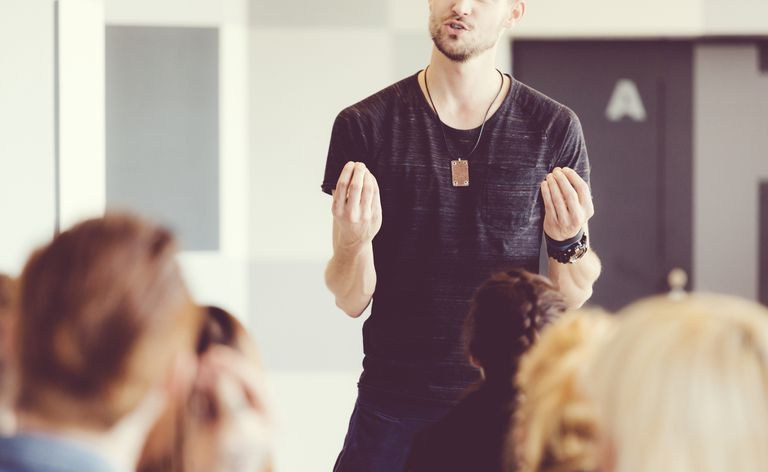 Un homme parle devant un groupe.