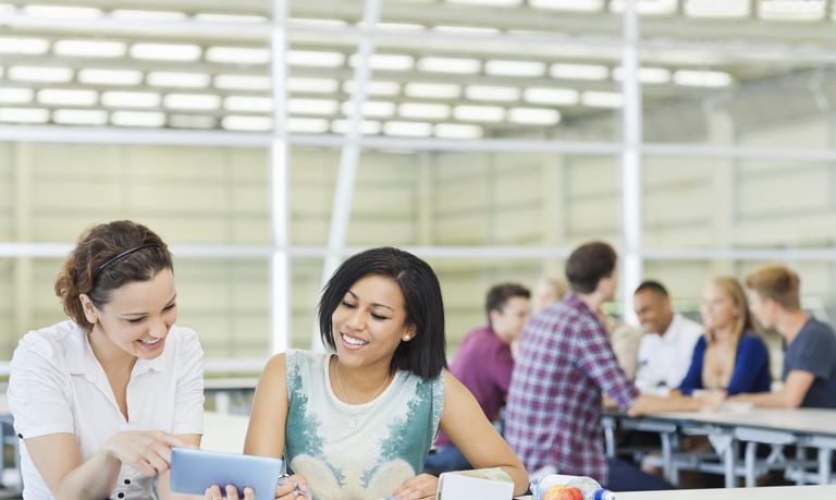 Estudiantes universitarios que usan una tableta digital en la cafetería