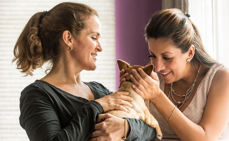 別の女性に自分の子犬を見せる女性