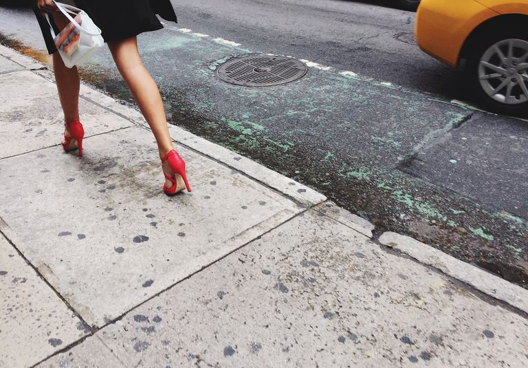 Seção baixa da mulher andando na rua