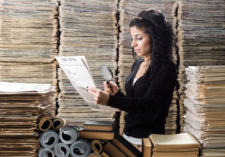 Ung kvinne med blandet rase som forsker i mediebiblioteket