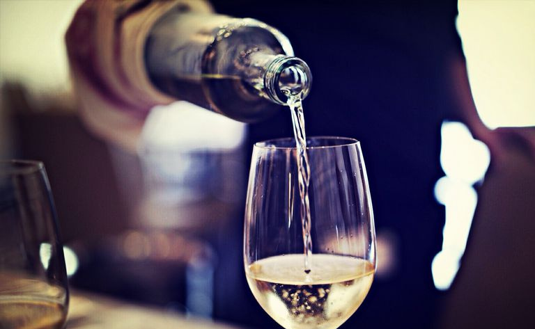 Meio do garçom servindo vinho no copo no restaurante