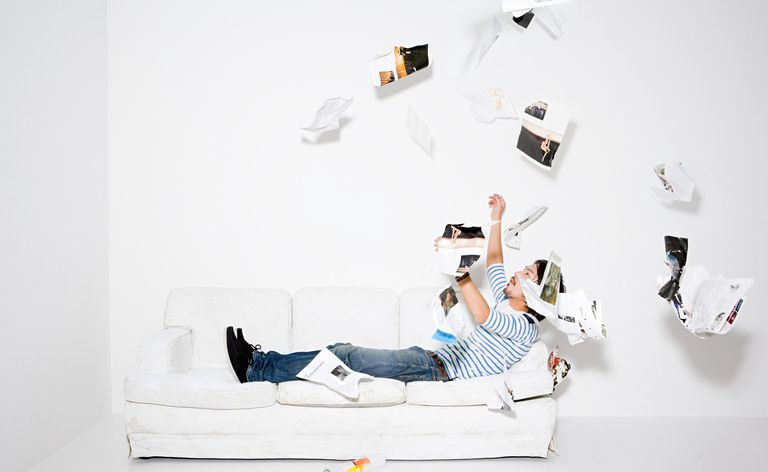 Hombre lanzando páginas de una revista