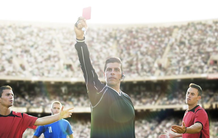 Exalando equilíbrio em circunstâncias difíceis, um árbitro mostra um cartão vermelho em uma partida de futebol