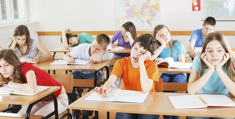 Barn ser lei seg med notatbøker i et klasserom