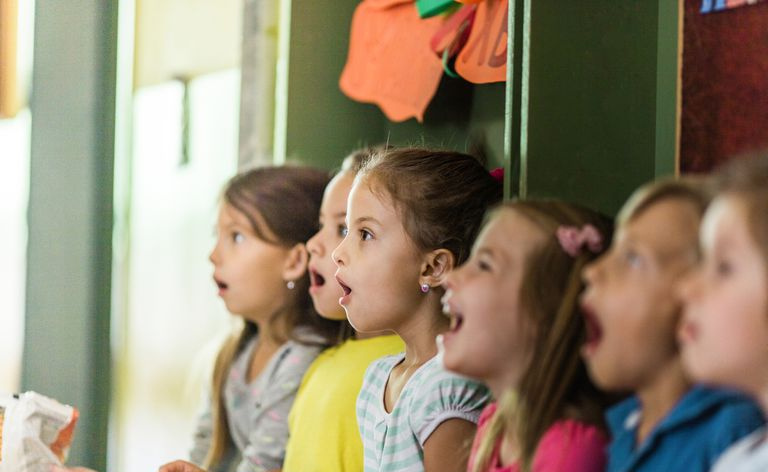 Grupo de crianças cantando na escola
