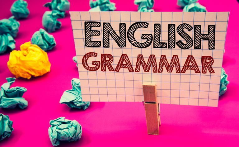 Nota de escritura que muestra la gramática inglesa. Exhibición de fotos de negocios Conocimiento del idioma Escuela Educación Literatura Lectura Pinza para la ropa sostener papel blanco letras rojas negras papeles arrugados.