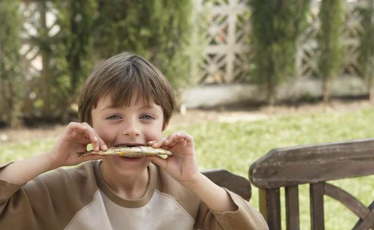 Ragazzo che mangia una sardina