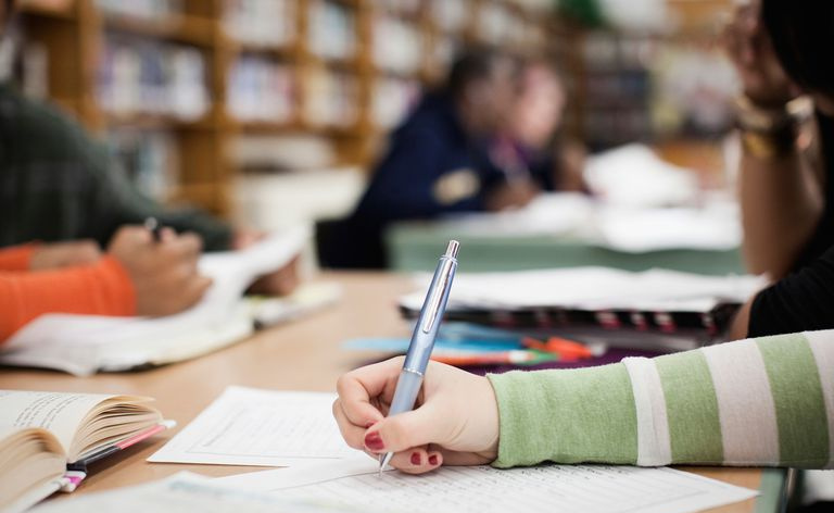 Student utarbeider et essay i et bibliotek