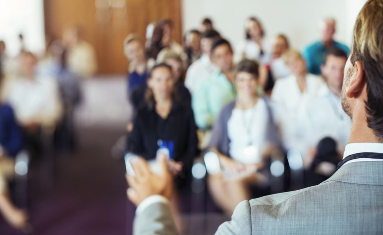 Un hombre dando un discurso en una sala de conferencias.