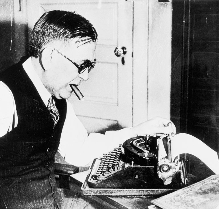 H. L. Mencken arbeitet mit einer Zigarre im Mund