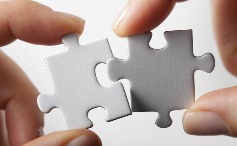 ręce łączące dwa kawałki puzzli