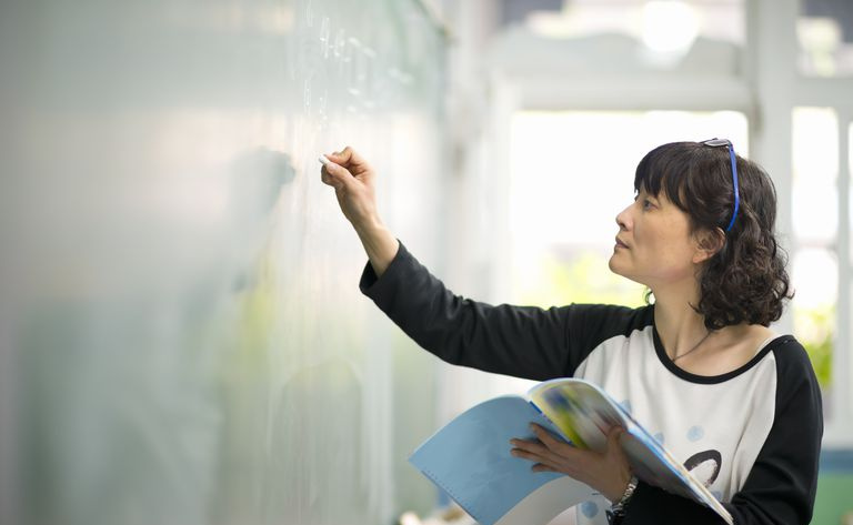 Professeur écrivant sur le tableau