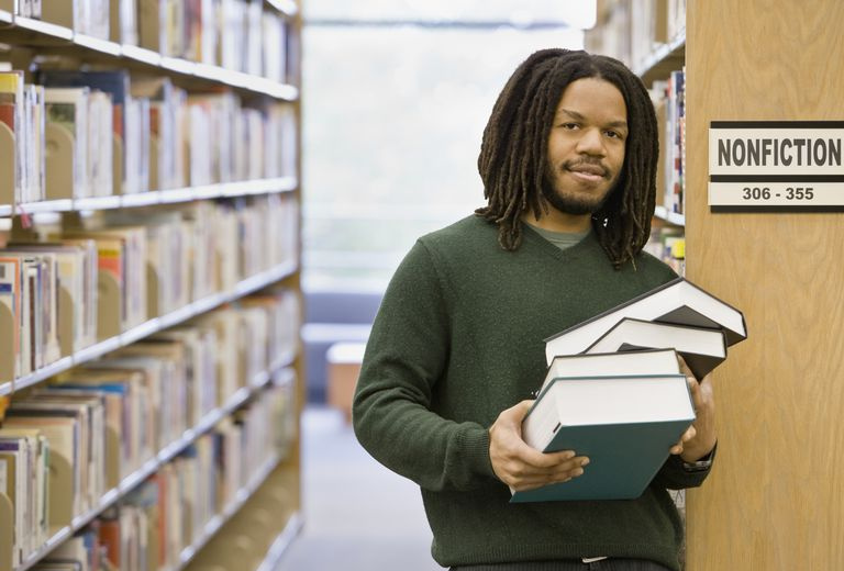 uomo nella sezione saggistica della biblioteca con libri