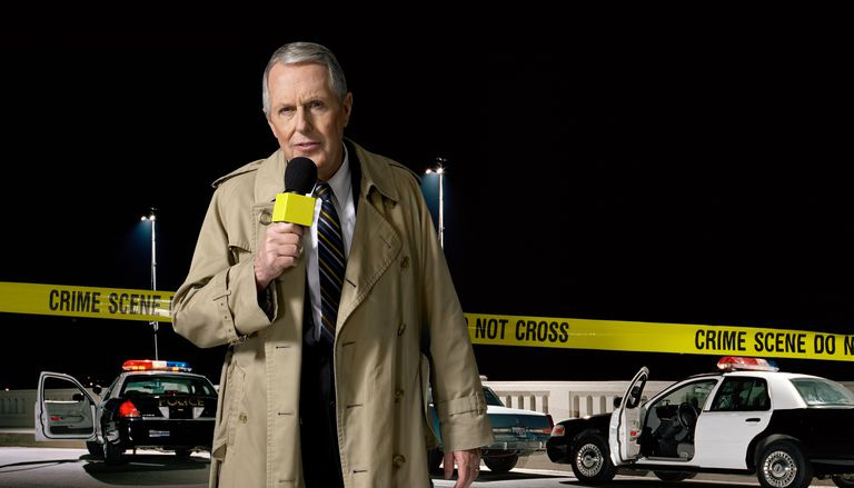 Presentador de noticias en la escena del crimen