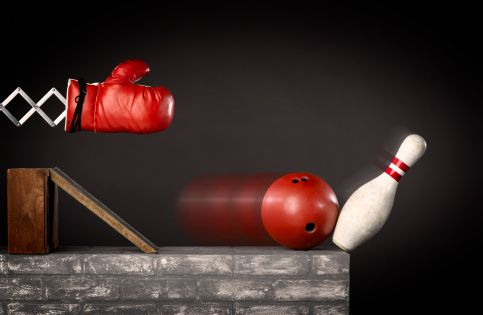 Gant de boxe frappant une boule de bowling et une épingle