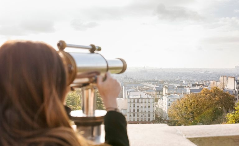 Mujer mirando a través del telescopio
