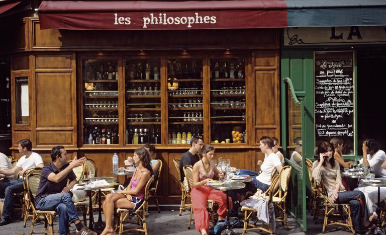 La gente cena en la terraza de un café en París