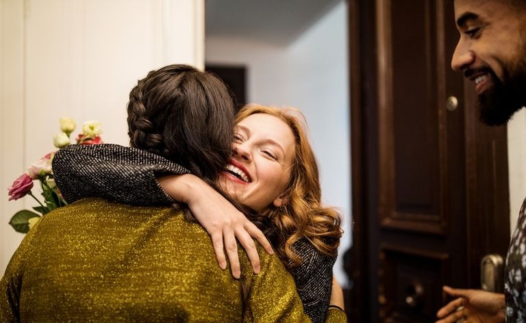 Mujer abrazando a un amigo durante la visita para la cena