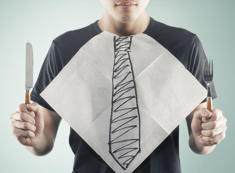 vīrietis ar priekšautiņu, uz kura ir uzvilkta kaklasaite